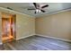 Living room showing updated flooring, a ceiling fan, and a view into the kitchen at 1877 Pine Cone Cir, Clearwater, FL 33760