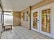 Enclosed patio featuring neutral tile and furniture, a transition between indoors and outdoors at 1877 Pine Cone Cir, Clearwater, FL 33760