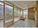 Relaxing enclosed patio with white tile floors and screens, designed for outdoor enjoyment and comfort at 1877 Pine Cone Cir, Clearwater, FL 33760