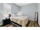 Cozy bedroom features a comfortable bed, wood-look floors, and a window with blinds at 18773 Lake Worth Blvd, Port Charlotte, FL 33948