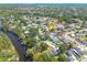 An aerial view shows the location of a charming home near a river with pool, and mature trees around the perimeter at 1913 Libby Ct, Holiday, FL 34690