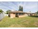 Spacious backyard with a large lawn, patio area, and mature trees at 1913 Libby Ct, Holiday, FL 34690