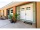Inviting entryway with double doors, decorative plants, and a neutral color scheme at 1913 Libby Ct, Holiday, FL 34690