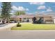 Charming single-story home features a well-manicured lawn and inviting front porch seating area at 1913 Libby Ct, Holiday, FL 34690