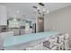 Bright kitchen with light blue breakfast bar, white cabinetry, stainless appliances and mosaic backsplash at 1913 Libby Ct, Holiday, FL 34690