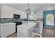 Bright kitchen featuring stainless steel appliances, white cabinets, and a central island at 1913 Libby Ct, Holiday, FL 34690