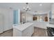 Spacious kitchen features an island, stainless appliances, light blue breakfast bar, and ample cabinet space at 1913 Libby Ct, Holiday, FL 34690