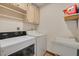 Functional laundry area with a washing machine, dryer, and utility sink at 1913 Libby Ct, Holiday, FL 34690