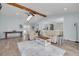 Open concept living room with wood beams, plenty of seating, and a view to the kitchen at 1913 Libby Ct, Holiday, FL 34690
