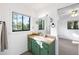 Bathroom with a vintage vanity, framed mirror, window, and a view into bedroom at 22004 Dupree Dr, Land O Lakes, FL 34639