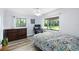Cozy bedroom featuring wood floors, a ceiling fan, and a view of the serene, green backyard at 22004 Dupree Dr, Land O Lakes, FL 34639