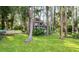 Exterior facade of home surrounded by trees and green grass, with boat and deck at 22004 Dupree Dr, Land O Lakes, FL 34639