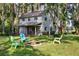 Charming two-story home with a fire pit and colorful Adirondack chairs on a spacious, lush green lawn at 22004 Dupree Dr, Land O Lakes, FL 34639