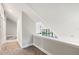 Upstairs hallway with carpet and views to the living area below through a dramatic window at 22004 Dupree Dr, Land O Lakes, FL 34639