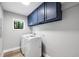 Laundry room with side-by-side washer and dryer and overhead storage cabinets at 22004 Dupree Dr, Land O Lakes, FL 34639