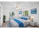 Stylized main bedroom featuring a plush bed, neutral colors, modern decor, and wooded views at 22004 Dupree Dr, Land O Lakes, FL 34639