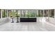 Bright sunroom featuring tiled floor, many windows overlooking green foliage, and modern bar at 22004 Dupree Dr, Land O Lakes, FL 34639