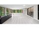Sunroom featuring tiled flooring, ample natural light, and a view of the trees at 22004 Dupree Dr, Land O Lakes, FL 34639