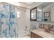 Clean bathroom featuring a shower-tub combo with a patterned shower curtain and vanity with ample storage at 2285 Hidden Meadows E Dr, Palm Harbor, FL 34683