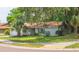 Inviting single-story home features a verdant lawn, mature trees, and a quaint front garden, creating a cozy ambiance at 2285 Hidden Meadows E Dr, Palm Harbor, FL 34683