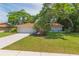 Charming single-story home with a manicured lawn, mature trees, and a neatly paved driveway, offering serene curb appeal at 2285 Hidden Meadows E Dr, Palm Harbor, FL 34683