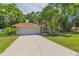 Attractive single-story home featuring a lush lawn, mature trees, and a spacious driveway, exuding welcoming curb appeal at 2285 Hidden Meadows E Dr, Palm Harbor, FL 34683