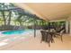 Spacious screened-in patio with a pool, alongside an outdoor seating area perfect for entertaining and relaxing at 2285 Hidden Meadows E Dr, Palm Harbor, FL 34683