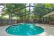 Refreshing screened-in pool with ample deck space, set against a backdrop of mature trees and a privacy fence at 2285 Hidden Meadows E Dr, Palm Harbor, FL 34683