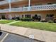 A condo's inviting outdoor space featuring a well-manicured lawn and cozy seating area for relaxation at 2457 Ecuadorian Way # 27, Clearwater, FL 33763