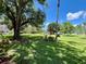 Green, lush, open community lawn with trees at 2457 Ecuadorian Way # 27, Clearwater, FL 33763