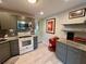 Bright kitchen features gray cabinets, stainless steel microwave, granite countertops, and wood-look tile floors at 2457 Ecuadorian Way # 27, Clearwater, FL 33763