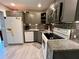 Updated kitchen features gray cabinets, stainless steel appliances, modern tile backsplash, and wood-look tile floors at 2457 Ecuadorian Way # 27, Clearwater, FL 33763