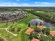 Aerial view featuring a meticulously maintained golf course and surrounding homes in a scenic landscape at 2516 New Haven Cir, Sun City Center, FL 33573