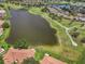 Aerial view of a golf course, lake, and neighborhood homes, providing a picturesque landscape at 2516 New Haven Cir, Sun City Center, FL 33573