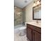 Bathroom with a glass enclosed shower-tub, a single vanity, and wood-style cabinetry at 2516 New Haven Cir, Sun City Center, FL 33573