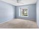 Bedroom with plush carpet, light blue walls, and a window with natural light and neighborhood views at 2516 New Haven Cir, Sun City Center, FL 33573