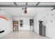 Clean garage with epoxy flooring, overhead storage, white cabinets, and a functional water filtration system at 2516 New Haven Cir, Sun City Center, FL 33573