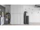Bright garage featuring epoxy flooring, storage cabinets, water heater, and water filtration system at 2516 New Haven Cir, Sun City Center, FL 33573