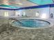 Indoor community hot tub, with tiled floors, white walls and a bright blue painted ceiling at 2516 New Haven Cir, Sun City Center, FL 33573