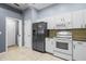 Modern kitchen with stainless steel appliances, white cabinetry, and stylish tile floors at 2516 New Haven Cir, Sun City Center, FL 33573