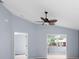 Light-filled living space with fan, gray walls, and view to screened lanai at 2516 New Haven Cir, Sun City Center, FL 33573