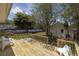 Wide angle view of a wooden deck with an outdoor dining set and backyard with trees at 2710 10Th N St, St Petersburg, FL 33702