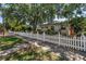 Wide view of a home surrounded by mature trees and a beautiful white picket fence at 2710 10Th N St, St Petersburg, FL 33702
