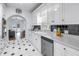 Kitchen featuring white cabinets, black hardware, a stainless steel dishwasher, and a view to living area at 2710 10Th N St, St Petersburg, FL 33702