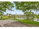 Waterfront backyard with lush landscaping and a patio overlooking a tranquil lake setting at 3559 Rock Royal Dr, Holiday, FL 34691