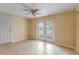 Bedroom features tile floors, ceiling fan, and glass doors for outdoor access and natural light at 3559 Rock Royal Dr, Holiday, FL 34691