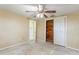 Bedroom featuring standard ceiling fan, door to a room, and a closet with wood panels at 3559 Rock Royal Dr, Holiday, FL 34691