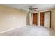 A bedroom features a ceiling fan and two closets with open doors to wooden interiors at 3559 Rock Royal Dr, Holiday, FL 34691