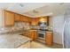 Well-lit kitchen boasts granite counters, stainless appliances, and stylish backsplash, ideal for cooking at 3559 Rock Royal Dr, Holiday, FL 34691