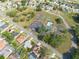 A high-angle shot showcases the community clubhouse and pool, as well as the tennis and basketball courts surrounded by trees at 3642 Fantasy Way, Brooksville, FL 34604